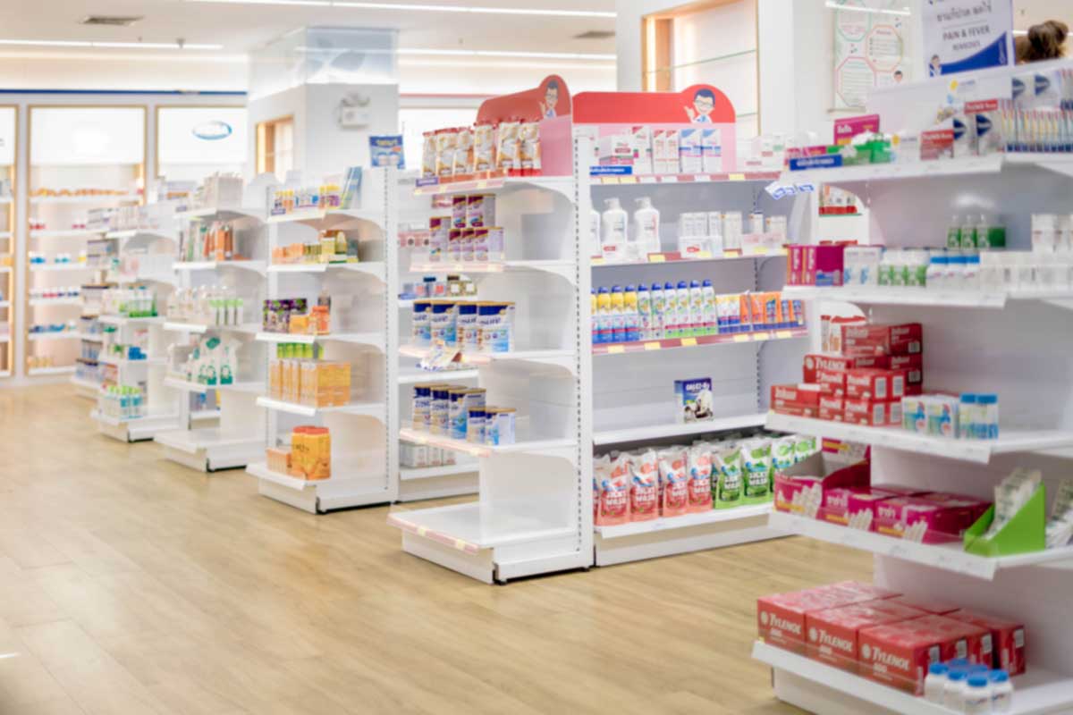 Pharmacy Drugstore Retail Interior Blur Abstract Background With Medicine Healthcare Product On Cabinet With Neon Light